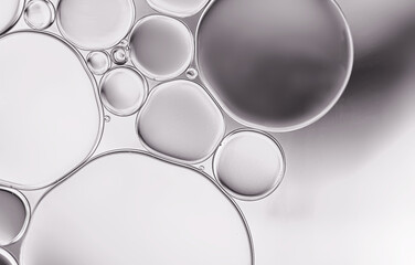 Oil droplets ,water surface with light efface on grey  background.