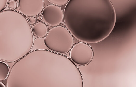 Oil bubbles on serum pattern with thatch or brown shand gradient light effect background.