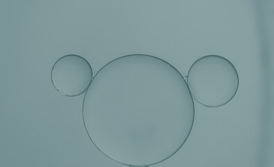 Oil droplets created an art image on blue-green light effects background.