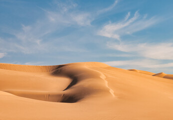 Fototapeta na wymiar Imperial sand dunes near Yuma, Arizona. Aerial with blue sky and puffy white clouds