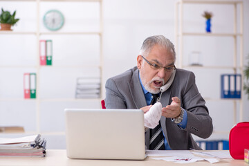 Old male employee cutting his hand in the office