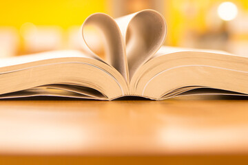 Book heart and valentine, Close up page of book in heart shape at library bookshelf of love to read and reading text book and February valentine day concepts.