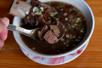 photo of a bowl of konro soup, a traditional food from Makassar, South Sulawesi. it looks appetizing.