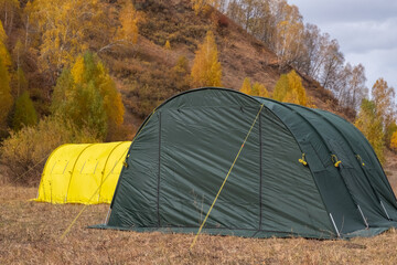 Large basecamp tents on colorful mountains background.