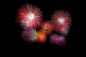 Many flashing colorful fireworks in event amazing with black background celebrate New Year, holiday and festival in night.
