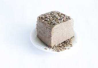 halva from sunflower seeds on a white plate. national traditional sweetness of turkish halva on the table. High quality photo