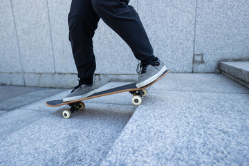 Skateboarder riding  skateboard goring down the stairs outdoors in city