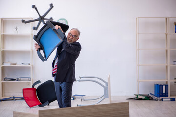 Old male employee working overtime in the office