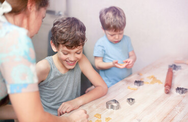Children with their mother are happily making cookies