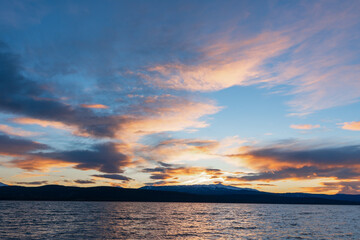 Sunset on a stunning lake in northern Canada during fall with pink, purple and orange toned sky on a peaceful and isolated lake. 