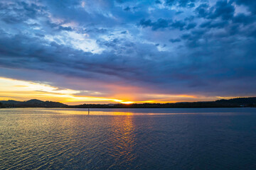 Sunrise waterscape with colourful cloud covered sky