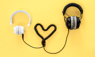 Flat lay musical background with black and white headphones.