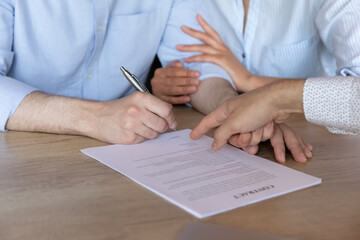 Close up cropped image happy young family couple signing paper contract with professional lawyer, real estate agent, financial advisor or broker, feeling satisfied with service at office meeting.