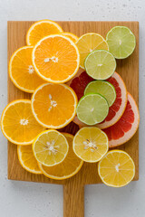 Fototapeta na wymiar Citrus composition on chopping board. Many halved lemons, limes, grapefruits. Vertical