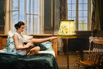 Woman in retro style interior puts on vintage stocking while sitting in bed