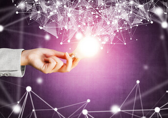 Woman hand holding light bulb and abstract network