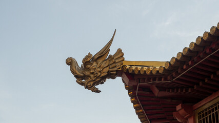 the figure of a dragon's head on the roof of a Buddhist pagoda