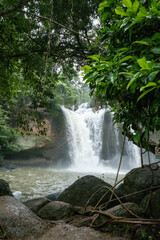 People watch the beautiful nature with trees and mountains, waterfalls. It is a tourist destination for a vacation.