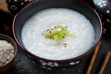 Close-up of a black bowl with congee or a type of rice porridge eaten in asian countries, selective focus
