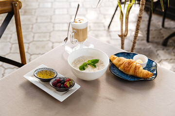 Served breakfast with porridge and croissant on restaurant table