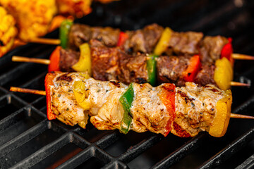 Grilling chicken kebab skewers and corn on a barbecue
