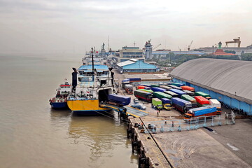 Vessels, passenger ships and tugboats in port under cargo operations and underway. Port of Surabaya, Indonesia, January,2021