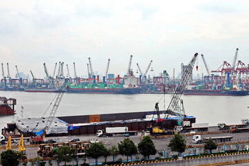 Vessels, passenger ships and tugboats in port under cargo operations and underway. Port of Surabaya, Indonesia, January,2021