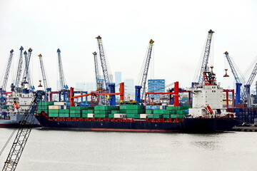 Vessels, passenger ships and tugboats in port under cargo operations and underway. Port of Surabaya, Indonesia, January,2021