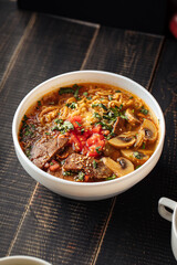 Bowl of korean beef ramen noodle soup with mushrooms