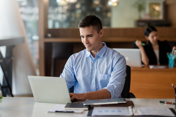 Fototapeta premium Businessman sitting working on laptop in office.