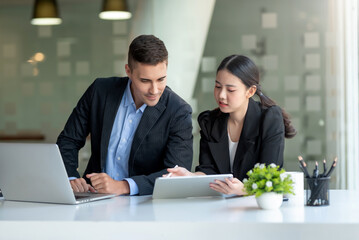 Businessman and businesswoman work together at office.