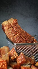 crispy pork belly in a basket with spicy sauce 