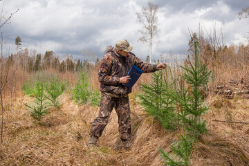 An ecologist oversees the growth and development of young trees in the forest.