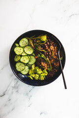 vegan nourish bowl with cucumber avocado and bean mix with spinach