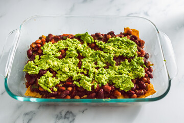 vegan nachos with corn chips bean mix and fresh gucamole, healthy plant-based food
