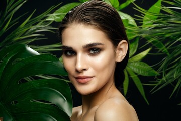 woman with bare shoulders green leaves clean skin cosmetology
