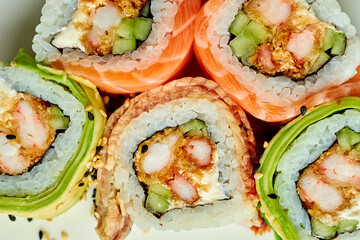 Close-up on sushi rolls with tempura shrimp, salmon and eel. Top view, close-up