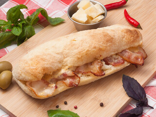 panini with bacon parmesan and cream sauce on a wooden board