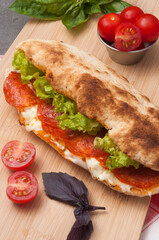 pepperoni panini with cream cheese and salad on a wooden board