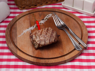 beef tenderloin steak on a round wooden board