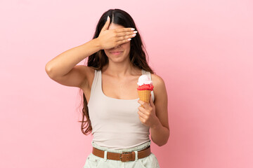 Young caucasian woman with a cornet ice cream isolated on pink background covering eyes by hands. Do not want to see something