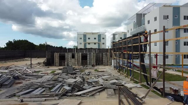 Drone avanzando estableciendo a zona de construccion de residenciales con estructuras base de edificios residenciales, la romana, republica dominicana
