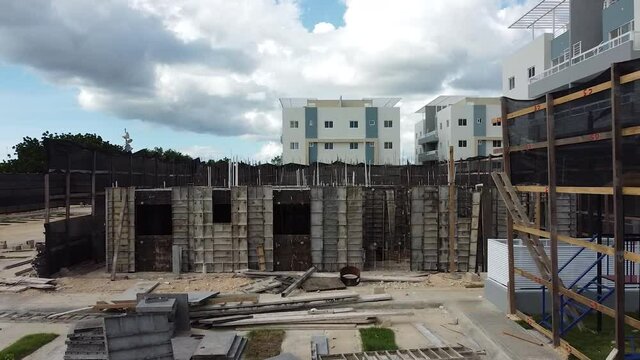 Drone avanzando estableciendo a zona de construccion de residenciales con estructuras base de edificios residenciales, la romana, republica dominicana