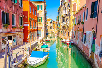Fototapeta na wymiar Sunny street with water canal in Venice, Italy