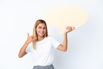 Blonde Uruguayan girl isolated on white background holding an empty speech bubble and doing phone gesture