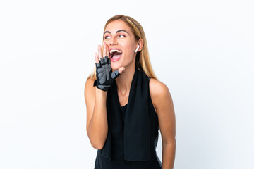 Blonde Uruguayan sport girl isolated on white background shouting with mouth wide open to the...