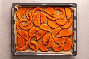 Chopped baked sweet butternut pumpkin on a baking sheet, top view