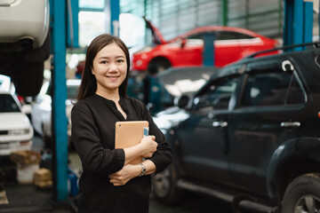 Fototapeta na wymiar Satisfied Asian young woman in black shirt showing a thumb up in garage.