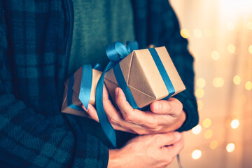 Hands holding gift box, present on the table and light of bokeh background. Valentine's Day, Christmas, Birth day, New year and Anniversary concept.
