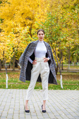 Young beautiful brunette girl walking in autumn park